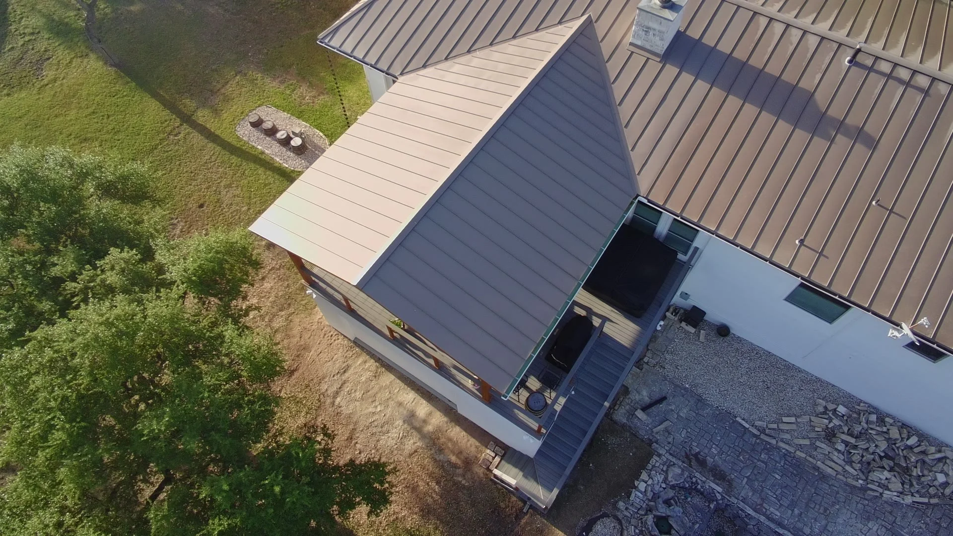 Drone shot showing standing-seam patio cover roof matched to Comal County residence