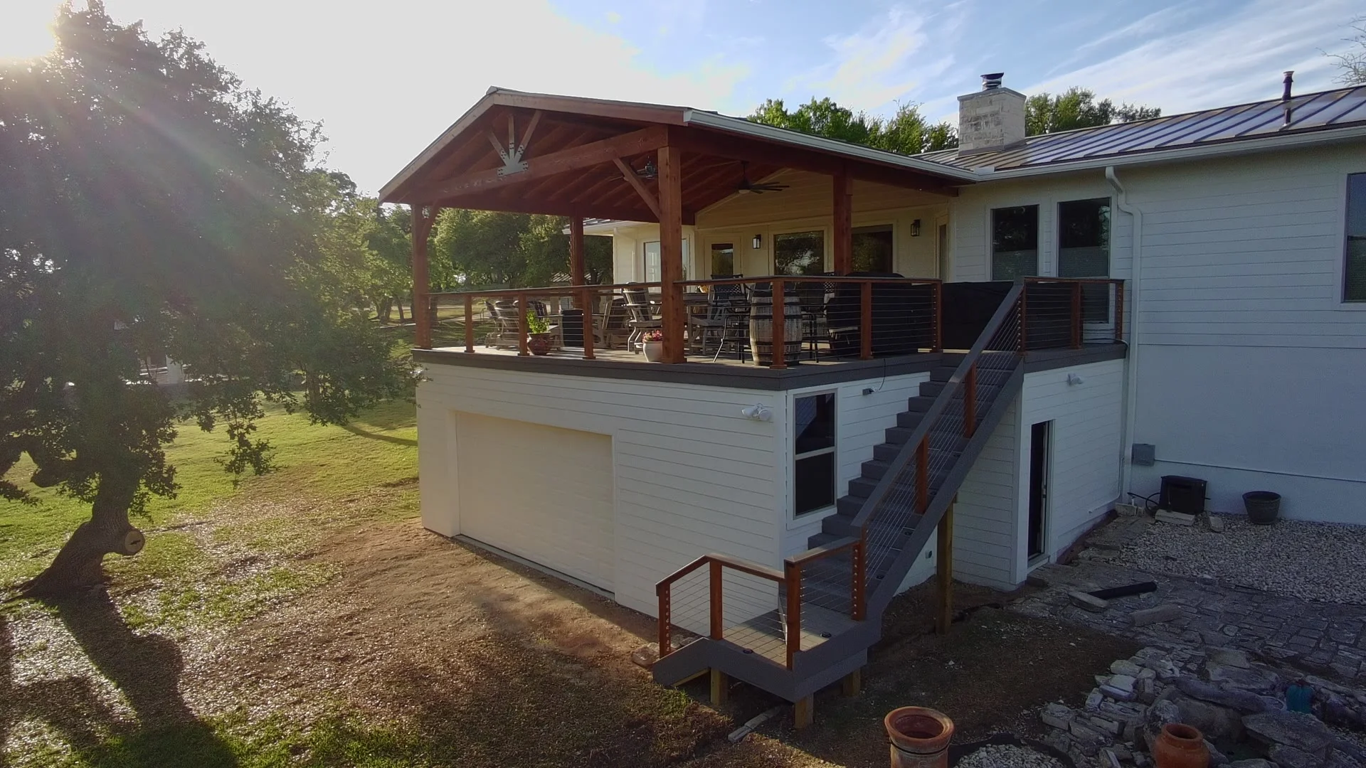 Elevated deck with cable-rail stairs and timber pavilion overlooking Texas Hill Country trees
