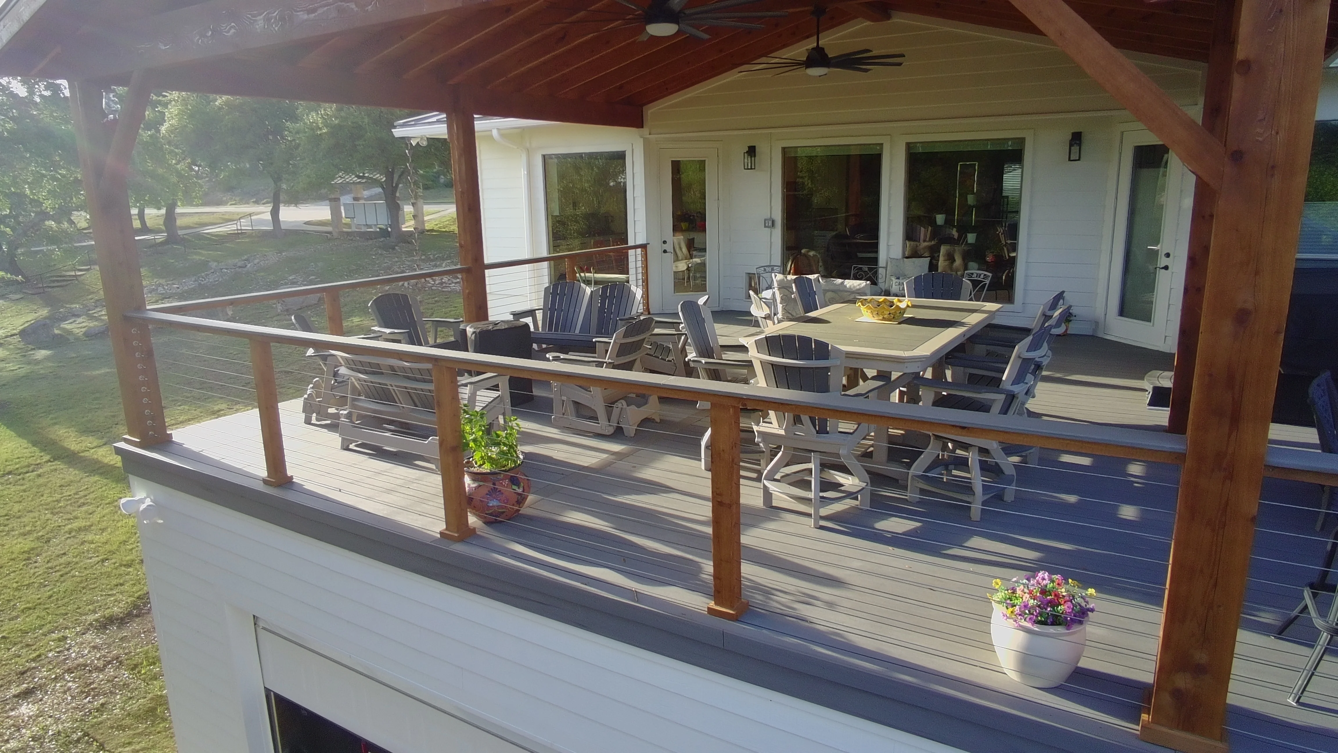 Covered outdoor living zones with tongue-and-groove ceiling and fans on elevated Hill Country deck