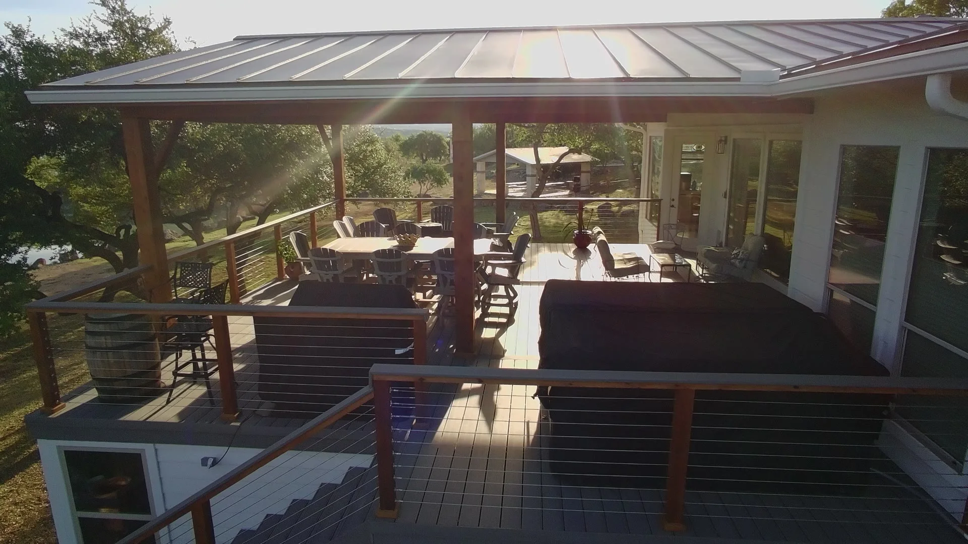 Cable railing deck and patio cover looking out over Comal County hills at golden hour