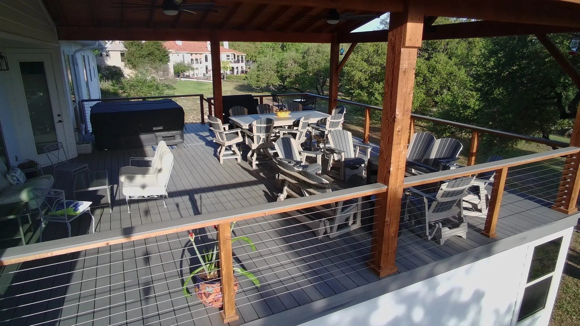 Multi-zone elevated deck with dining and lounge seating under timber patio cover near San Antonio